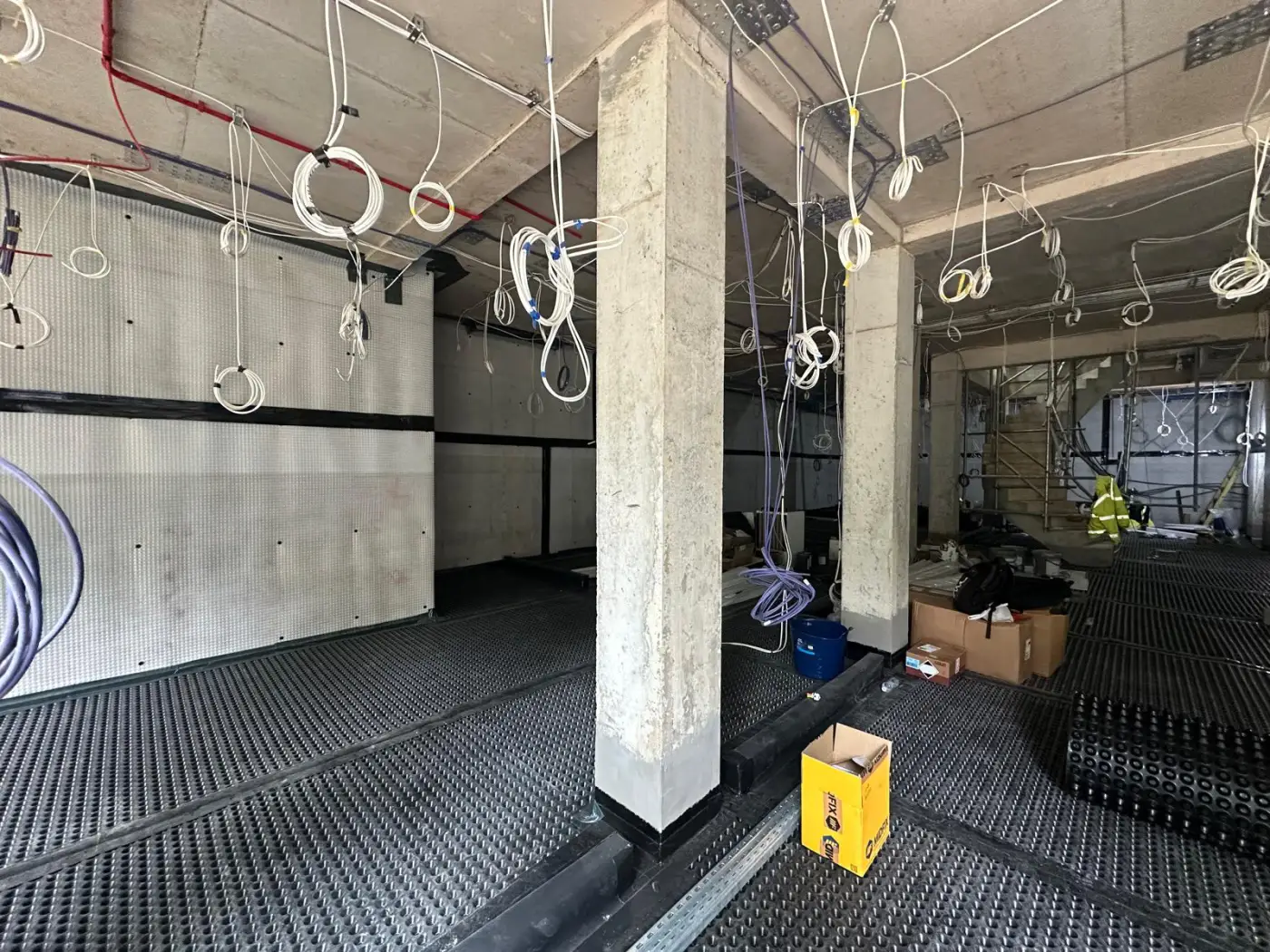 Cavity drain membrane between concrete columns at lower ground level
